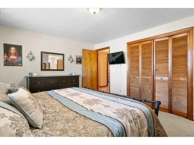 a bedroom with a large bed and a flat screen tv