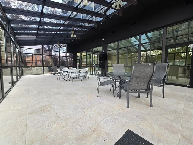 a view of a patio with table and chairs and a barbeque