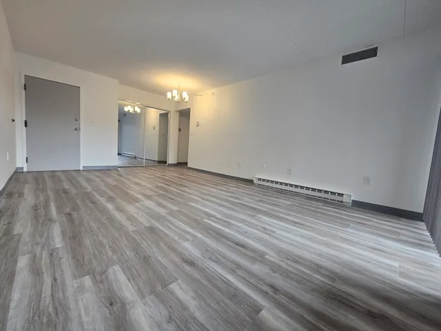 a view of an empty room and wooden floor