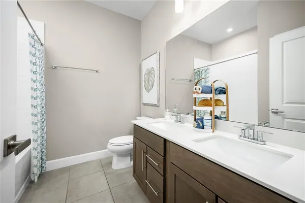 a bathroom with a double vanity sink toilet and a mirror