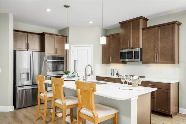 a kitchen with stainless steel appliances granite countertop a sink refrigerator and microwave