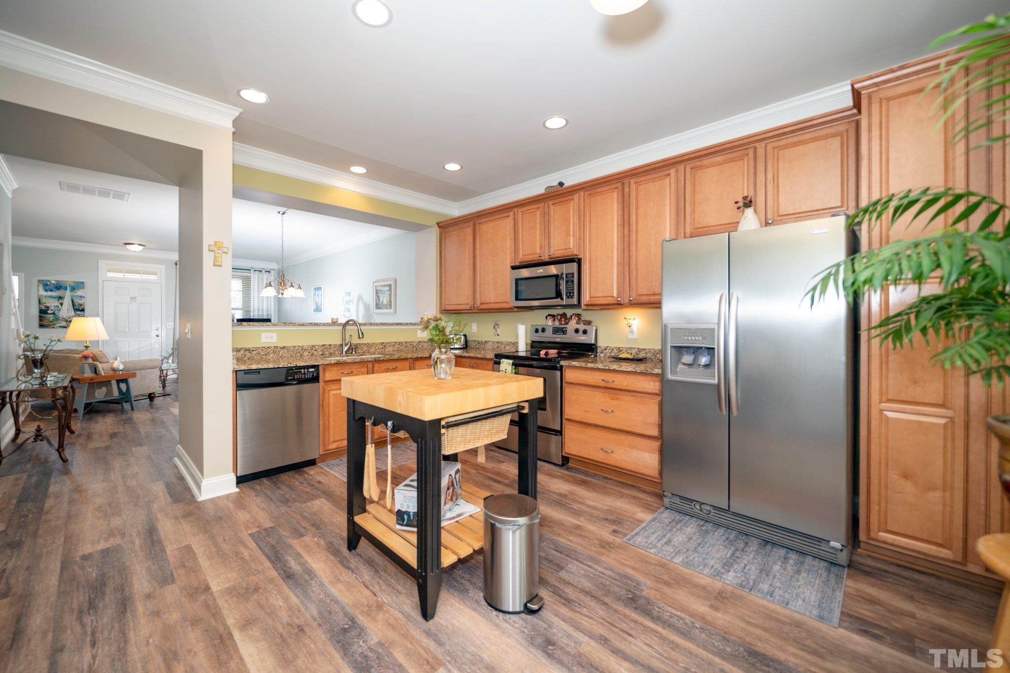 254 Duck Mill Circle Cary, NC 27519 - Photo 11 of 27 a kitchen with kitchen island granite countertop stainless steel appliances cabinets a sink and a counter top space