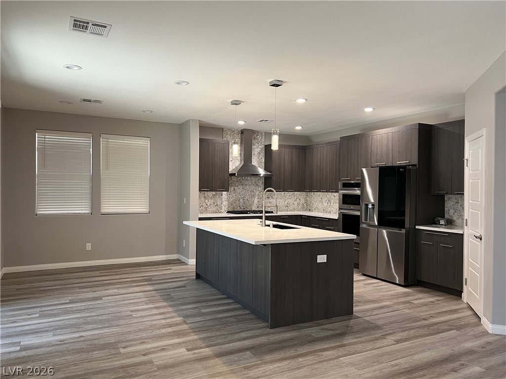 5981 Honeysuckle Ridge Street Las Vegas, NV 89148 - Photo 5 of 29 A contemporary kitchen features an inviting island with sleek counters and stainless steel appliances.