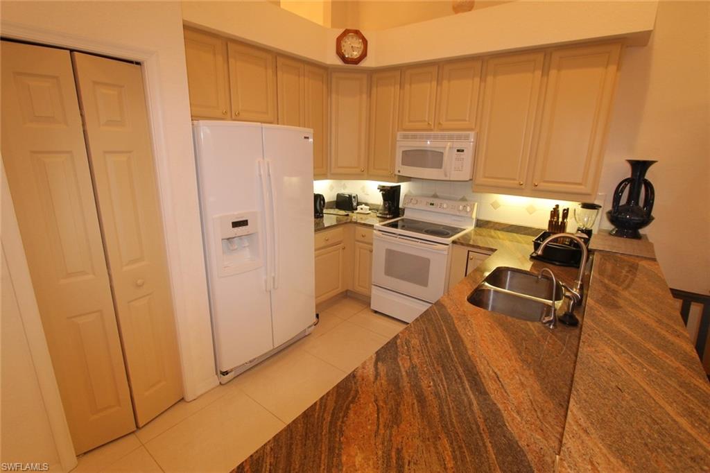 8526 Peppertree Way Naples, FL 34114 - Photo 6 of 14 a kitchen with stainless steel appliances a refrigerator a sink a stove and white cabinets