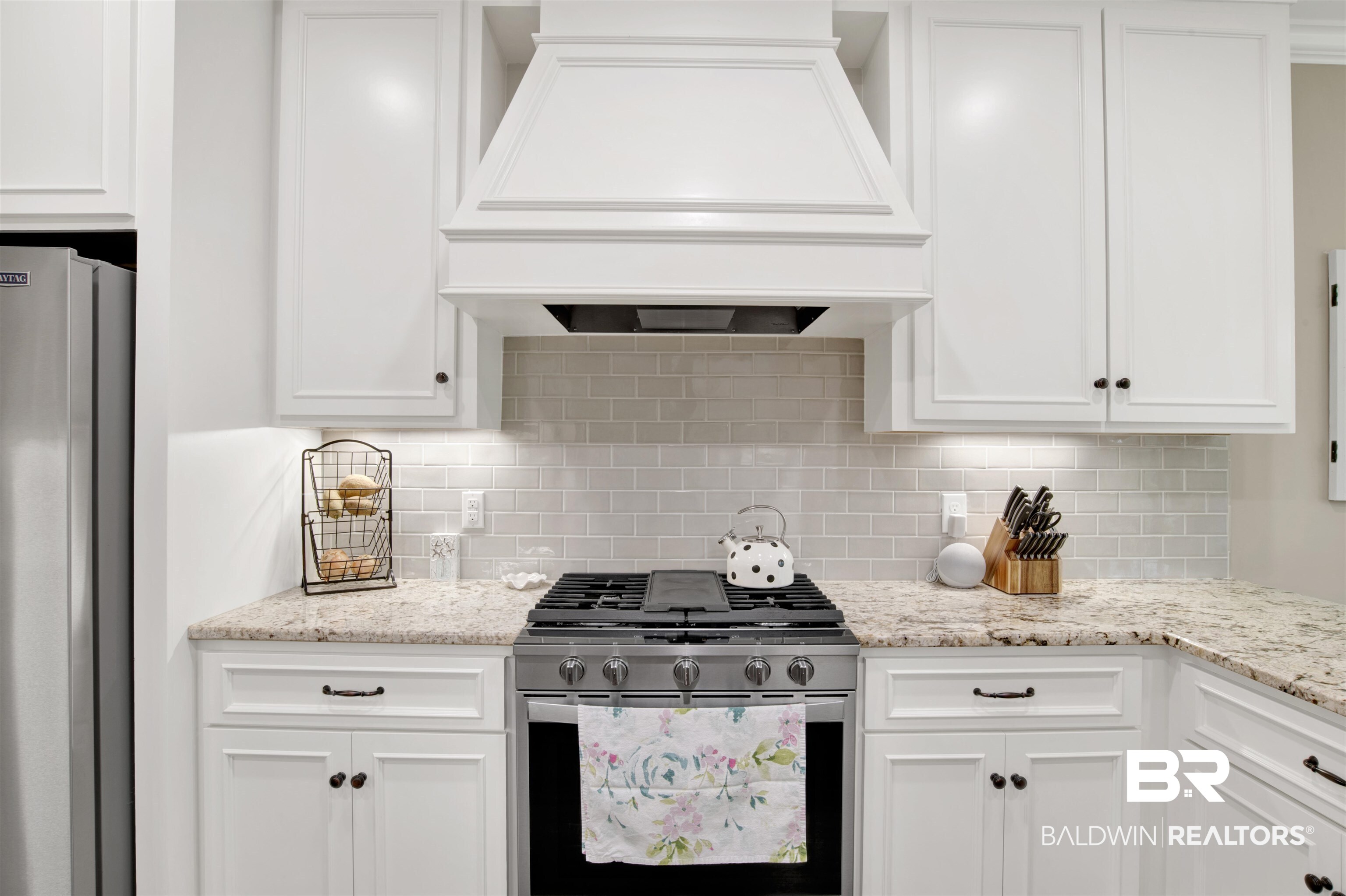 2440 Johnson Road West Mobile, AL 36695 - Photo 16 of 40 Kitchen featuring white cabinets, decorative backsplash, custom range hood, and stainless steel appliances