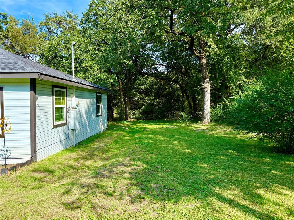 532 Marquette Avenue Azle, TX 76020 - Photo 13 of 32 a view of backyard with a barn and large trees