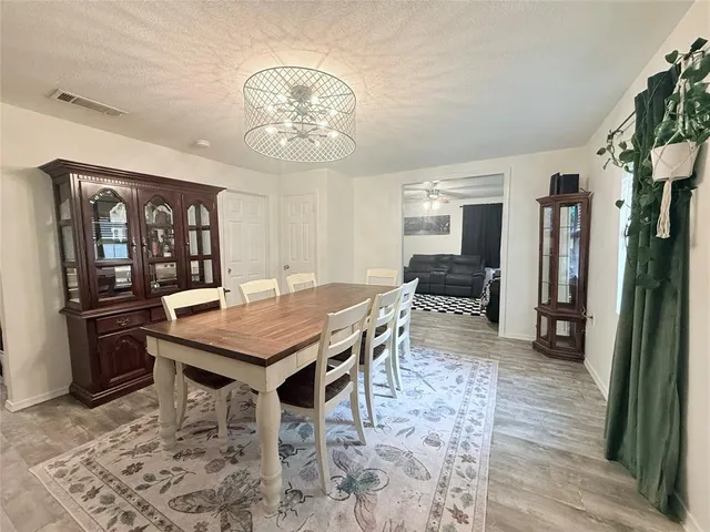a dining room with wooden floor and stainless steel appliances
