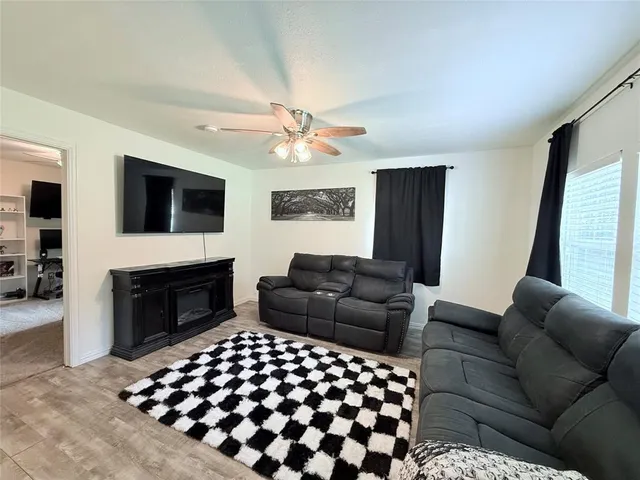 a living room with furniture a fireplace and a flat screen tv