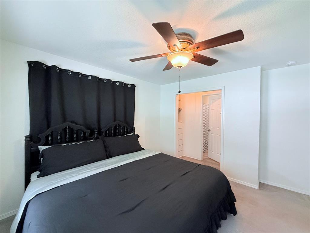 532 Marquette Avenue Azle, TX 76020 - Photo 23 of 32 a bedroom with a bed and a ceiling fan