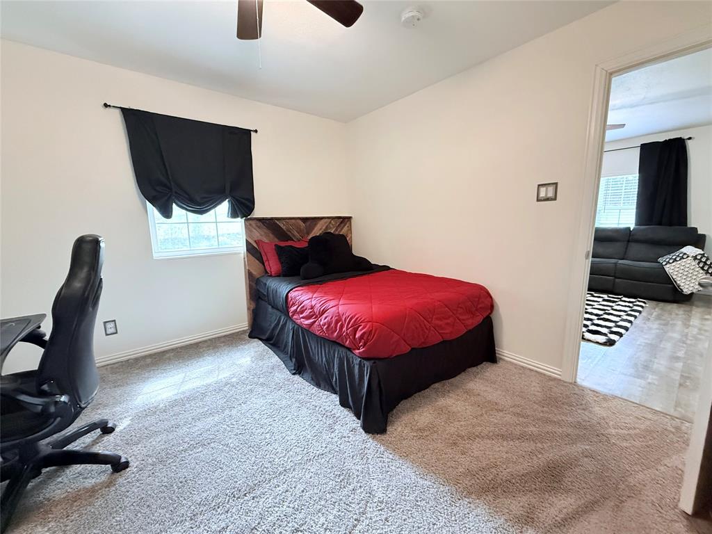532 Marquette Avenue Azle, TX 76020 - Photo 26 of 32 a bedroom with a bed and a flat screen tv