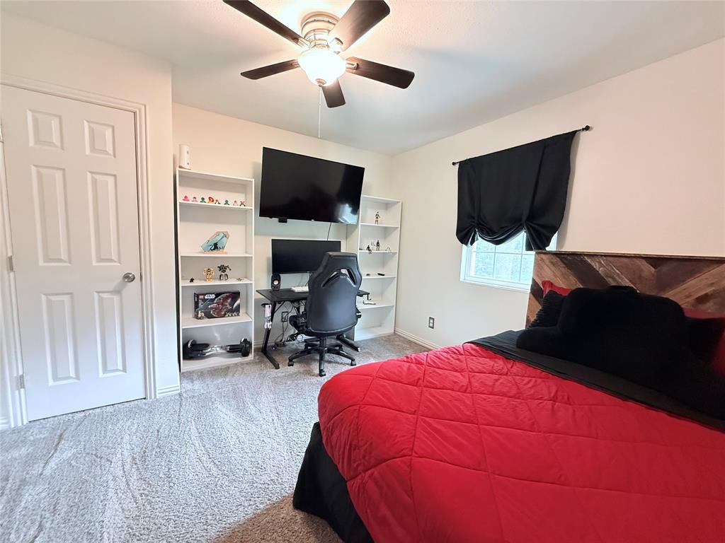 532 Marquette Avenue Azle, TX 76020 - Photo 27 of 32 a bedroom with a bed window and a flat screen tv