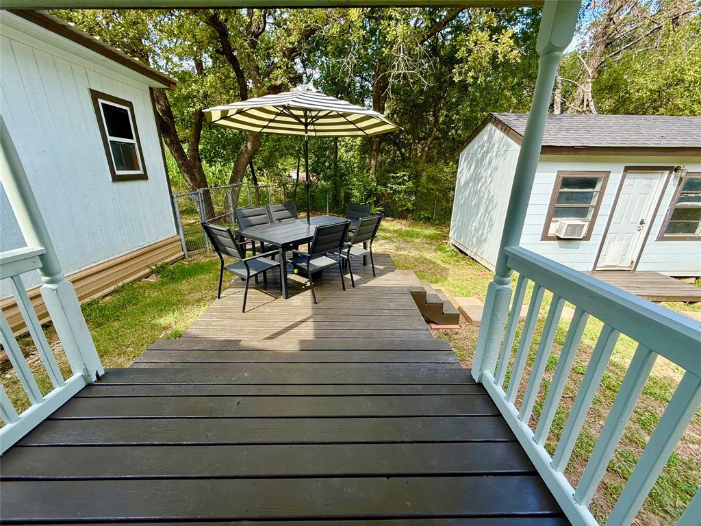 532 Marquette Avenue Azle, TX 76020 - Photo 9 of 32 a view of a patio with table and chairs under an umbrella with wooden floor