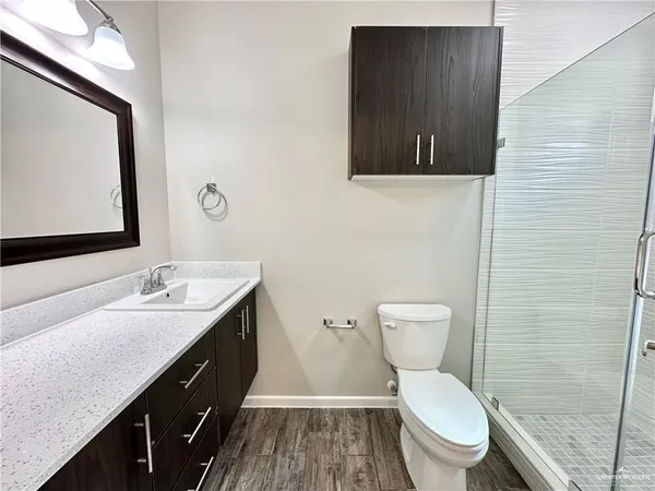 a bathroom with a granite countertop toilet sink and mirror