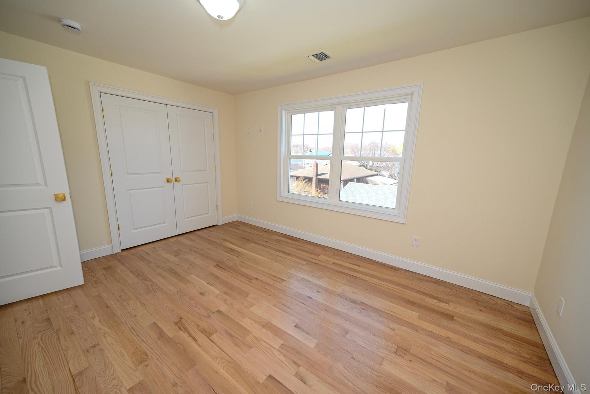 1772 Rose Street Merrick, NY 11566 - Photo 19 of 35 an empty room with wooden floor and windows