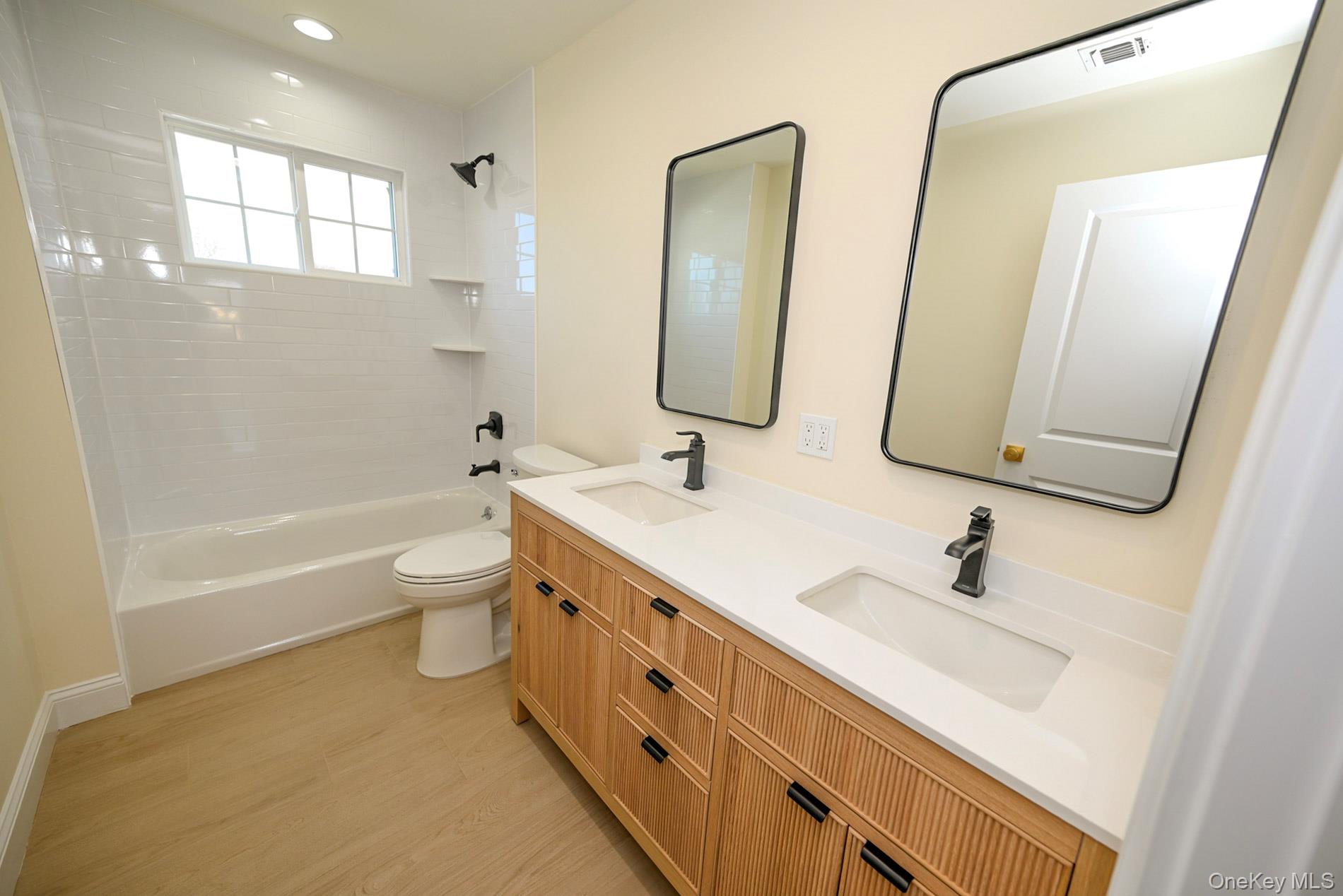 1772 Rose Street Merrick, NY 11566 - Photo 20 of 35 a bathroom with a double vanity sink a toilet a mirror and shower