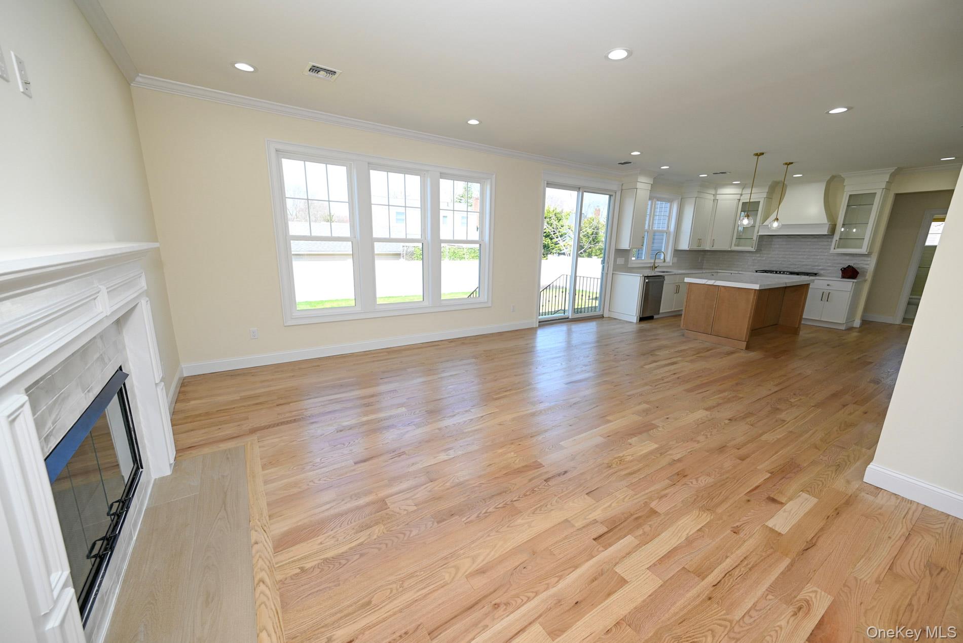 1772 Rose Street Merrick, NY 11566 - Photo 5 of 35 a view of an empty room with kitchen view and wooden floor
