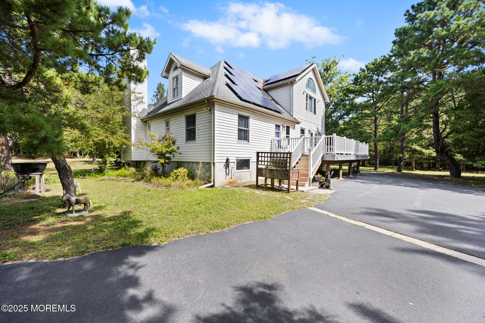 a view of a house with a yard and large trees