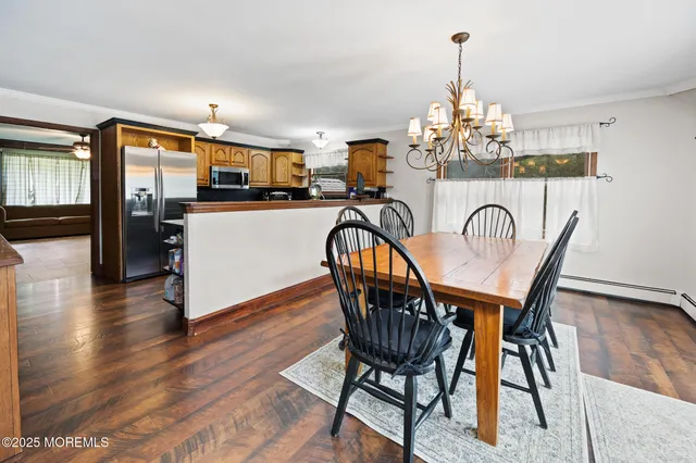 a dining room with furniture a chandelier and wooden floor
