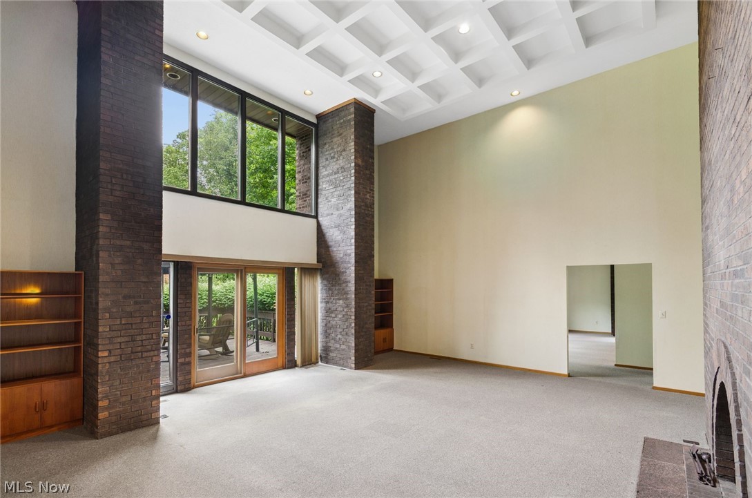 200 Hampshire Road Akron, OH 44313 - Photo 6 of 50 Voluminous living space featuring a coffered ceiling, floor-to-ceiling windows, and exposed brick columns
