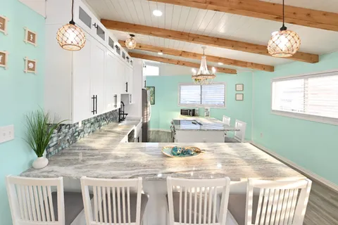 a kitchen with a stove a sink a dining table and chairs