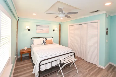 a bedroom with a bed and wooden floor