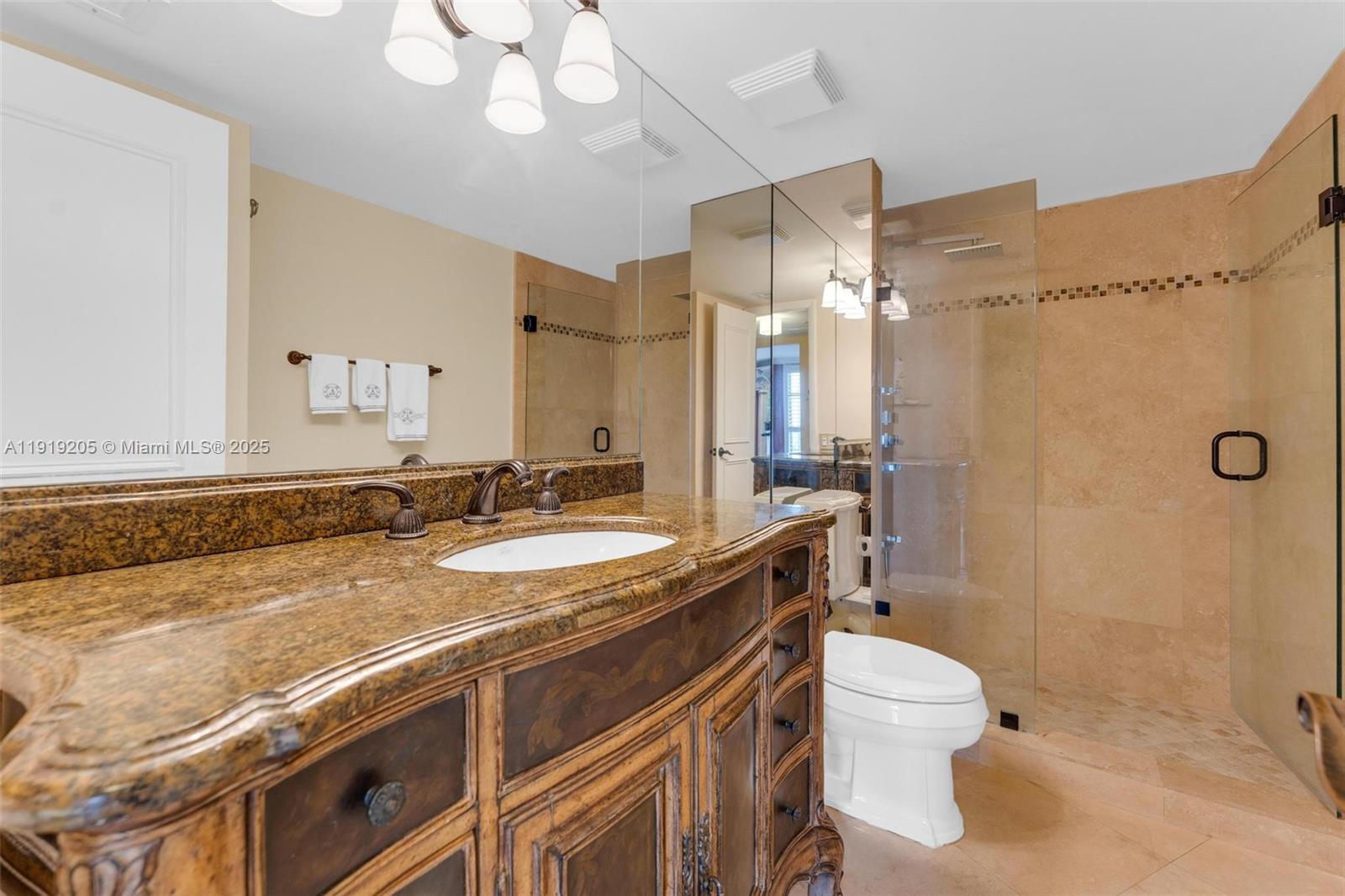 2000 Towerside Terrace, Unit 702 Miami, FL 33138 - Photo 22 of 37 a bathroom with a granite countertop sink mirror vanity and toilet
