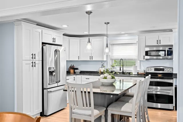 a kitchen with stainless steel appliances a refrigerator a stove a sink and a refrigerator