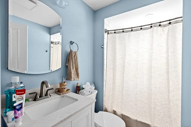 a bathroom with a sink vanity mirror and toilet