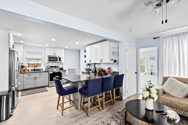 a living room with furniture kitchen and a dining table