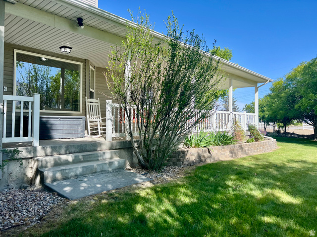812 East Bates Cyn Road Tooele, UT 84074 - Photo 101 of 144 Covered porch with white railings, a large picture window, and exterior lighting fixture