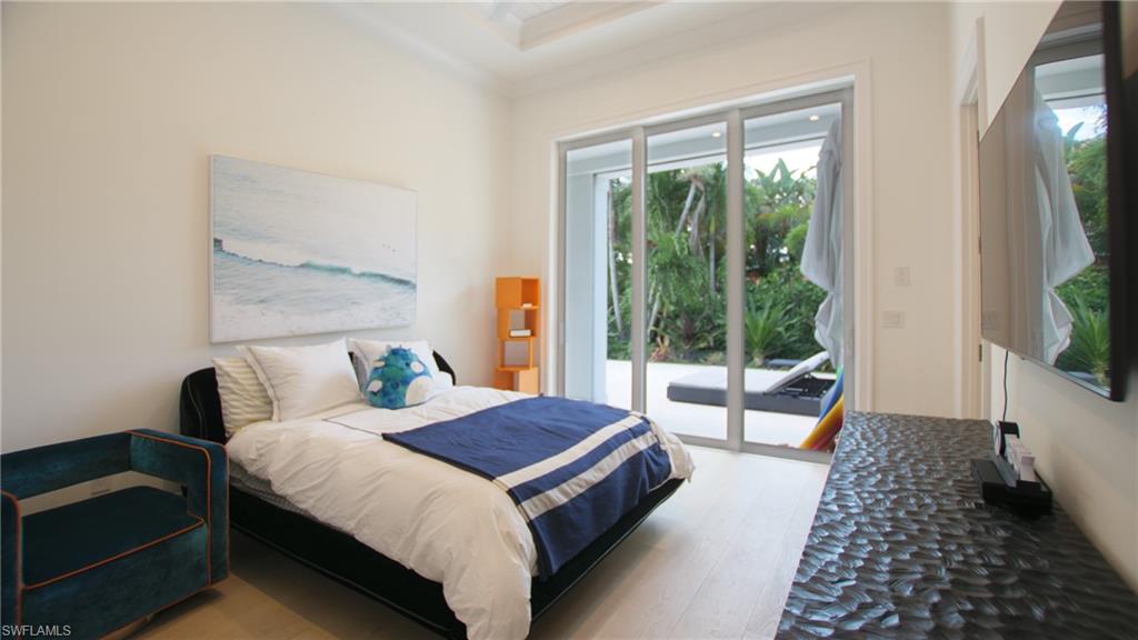 700 Wedge Drive Naples, FL 34103 - Photo 12 of 19 a bedroom with a bed and a large window