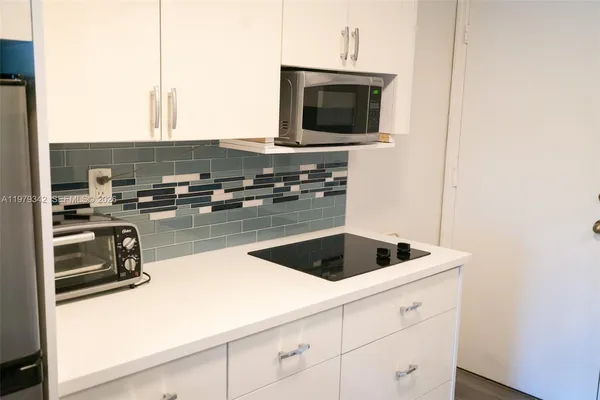 a kitchen with a sink a microwave and cabinets