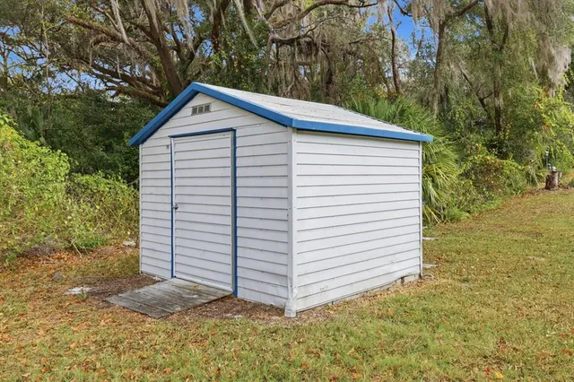a view of a house with a yard and large tree and plants