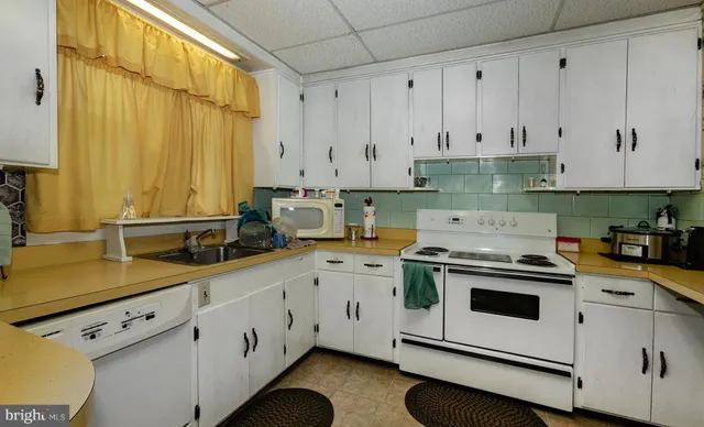 a kitchen with a sink a stove and cabinets
