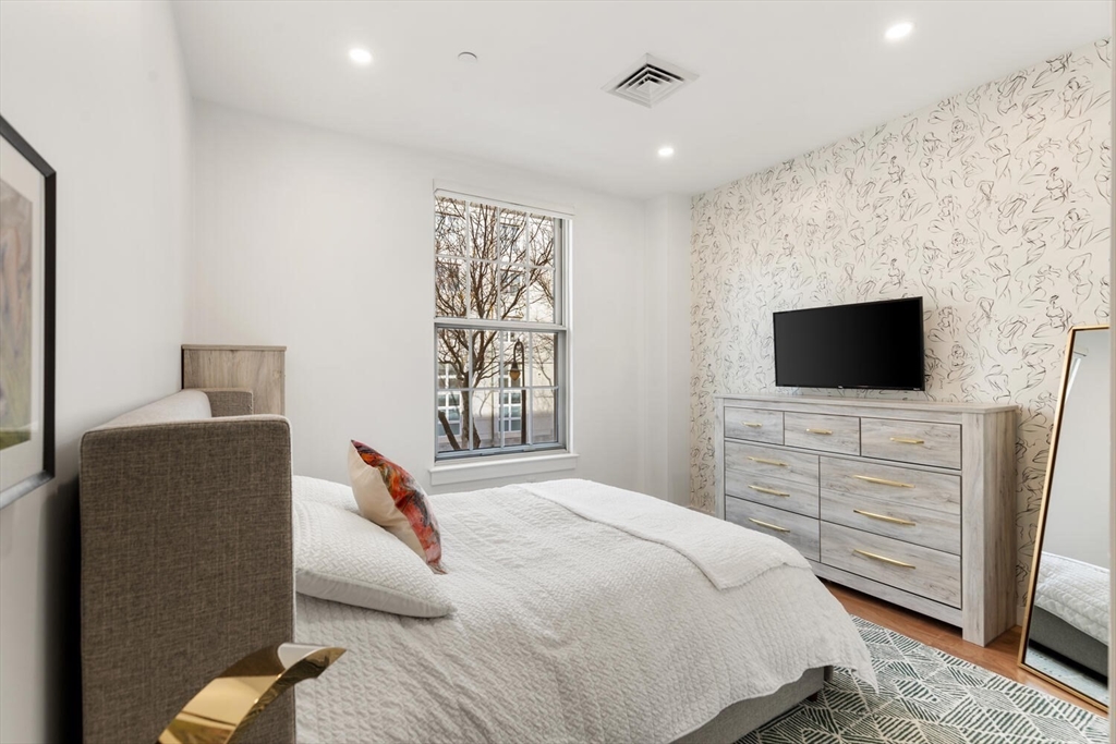 45 1st Avenue, Unit 202 Boston, MA 02129 - Photo 5 of 16 a bedroom with a bed and a flat screen tv