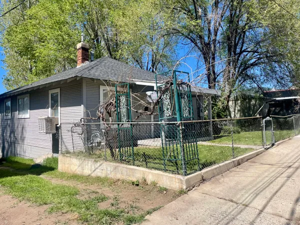 a view of a backyard with table and chairs potted plants and a large tree