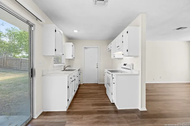 a kitchen with white cabinets and white appliances