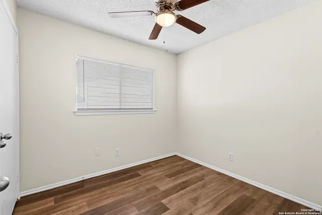 an empty room with a window and a fan