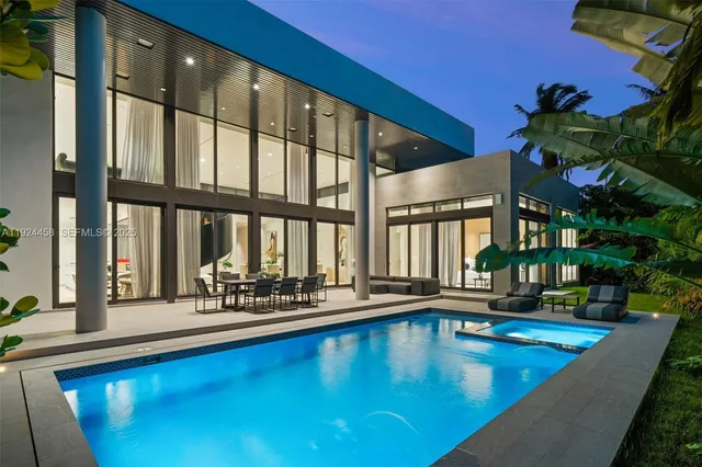 a view of a swimming pool with chairs in front of building