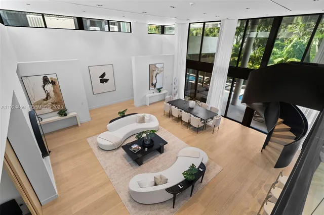 a living room with furniture floor to ceiling window and a flat screen tv