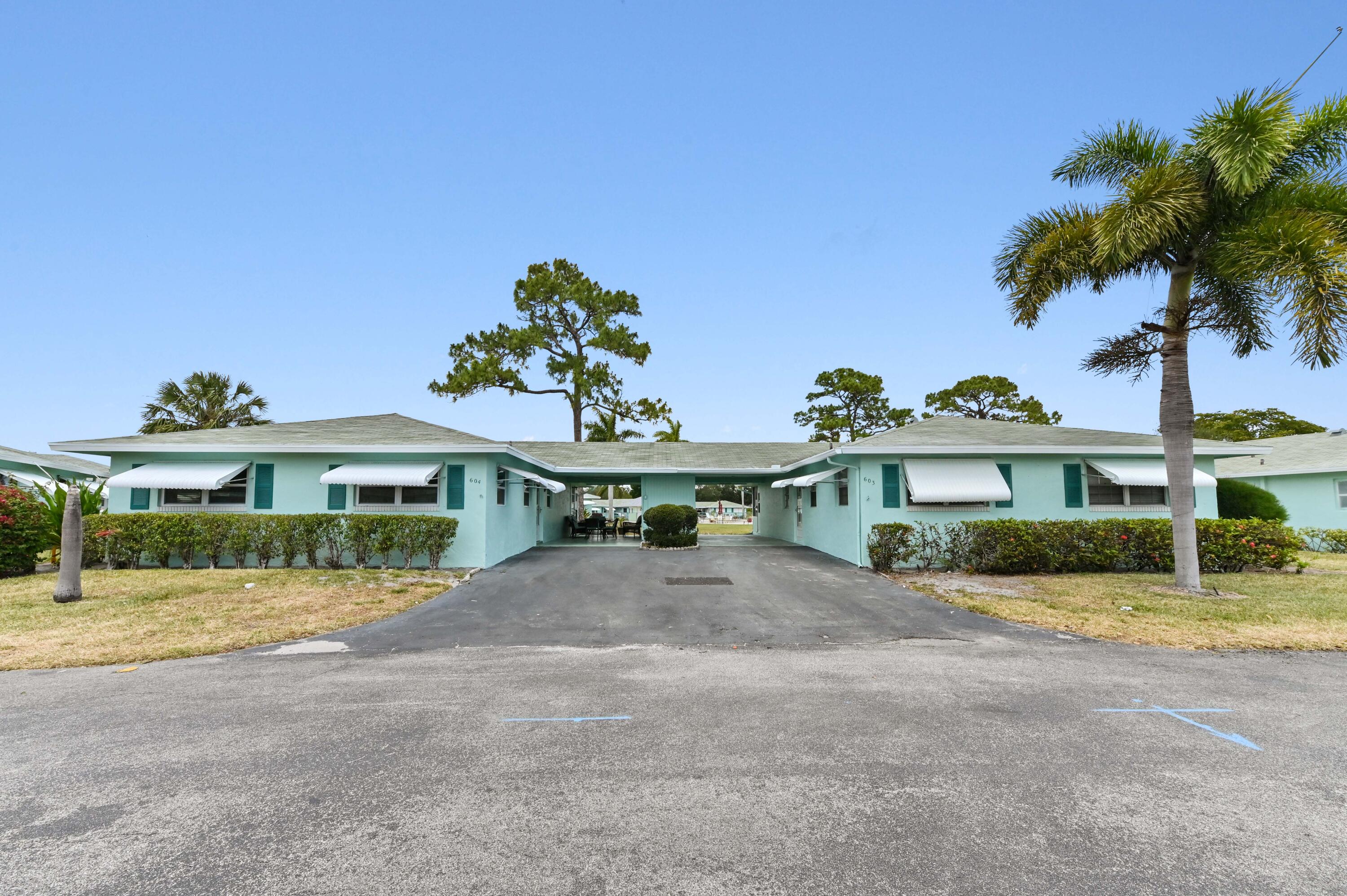 a front view of a house with a yard and potted plants