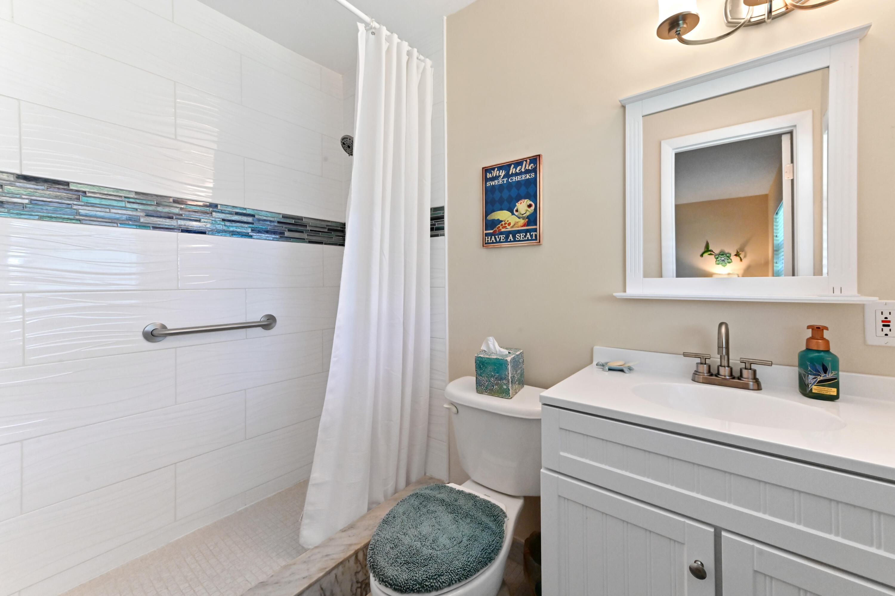 604 Hummingbird Lane Delray Beach, FL 33445 - Photo 18 of 32 a bathroom with a toilet a sink and mirror