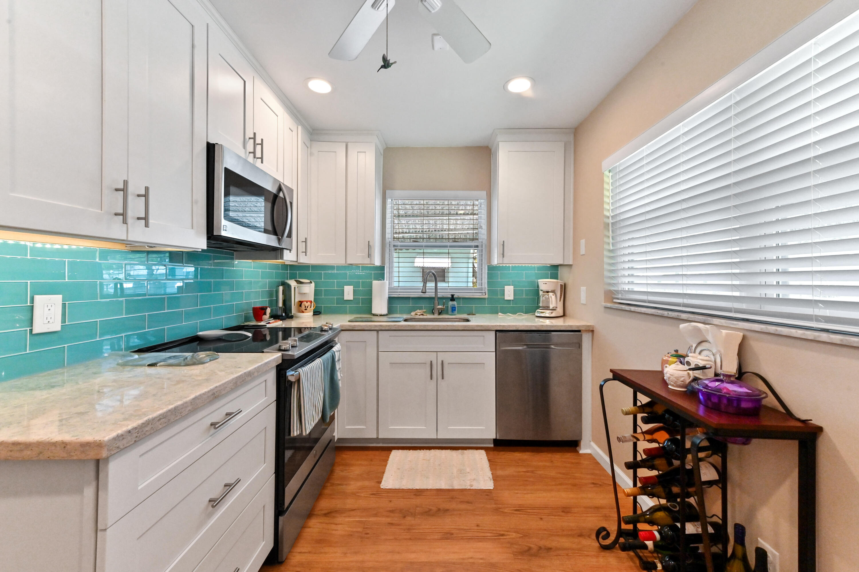 604 Hummingbird Lane Delray Beach, FL 33445 - Photo 10 of 32 a kitchen with stainless steel appliances granite countertop a stove a sink and a microwave