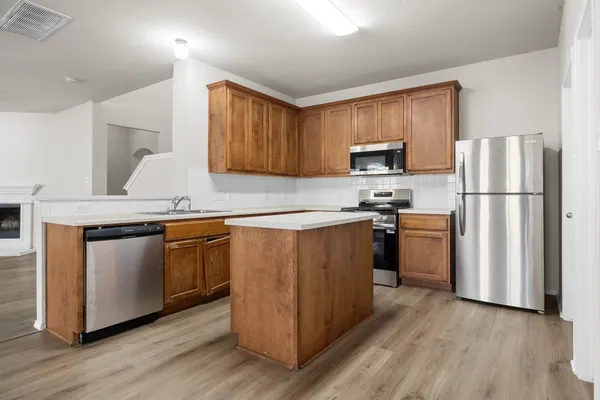 a kitchen with granite countertop a refrigerator stove top oven and sink