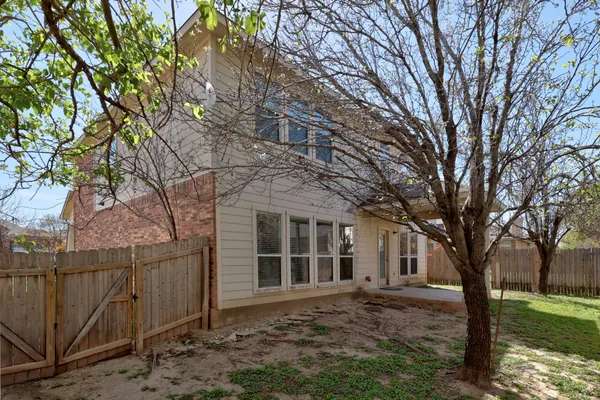 a view of a yard in front of a house with large tree