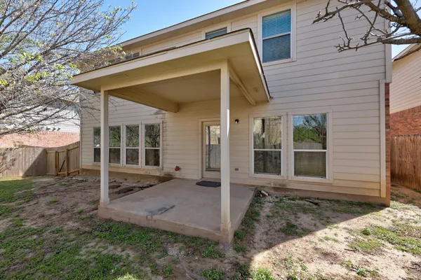 a view of a house with a large window and wooden fence