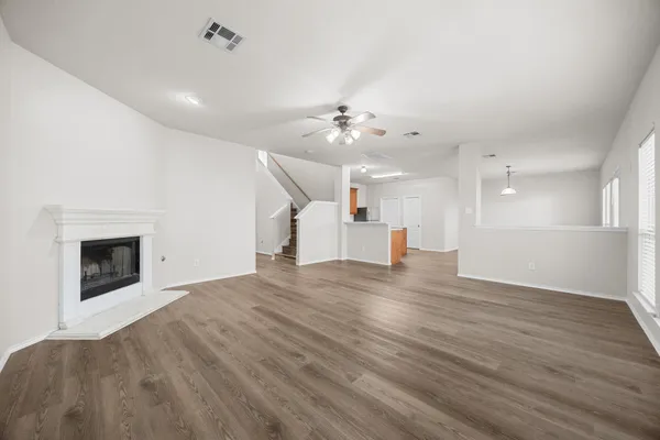 an empty room with wooden floor and fireplace