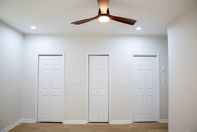 a large kitchen with a large counter top a sink stainless steel appliances and cabinets