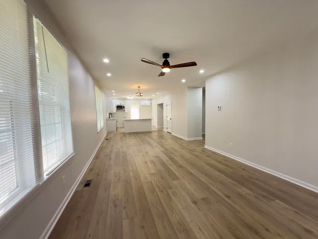 a view of a big room with wooden floor and a ceiling fan
