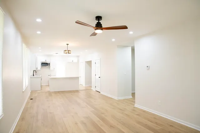 a large white kitchen with granite countertop a white cabinets and a fireplace